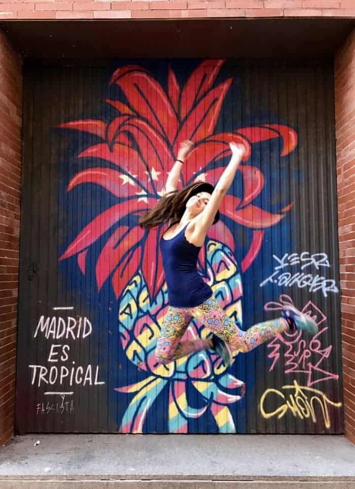woman jumping in front of graffiti