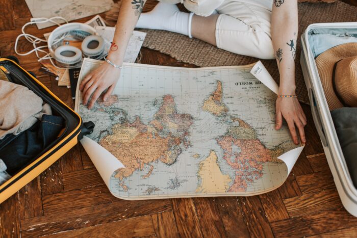 woman looking at world map on the floor of her room