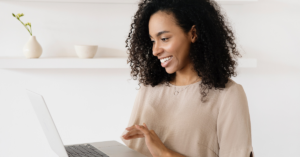 Black woman working on her laptop smiling