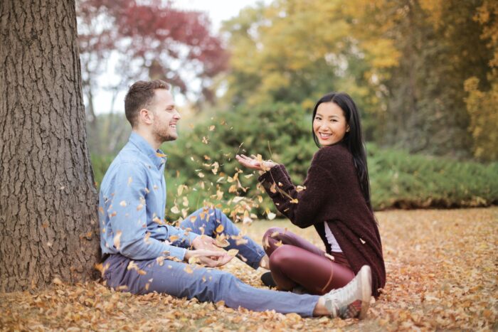 couple sitting and playing with leaves