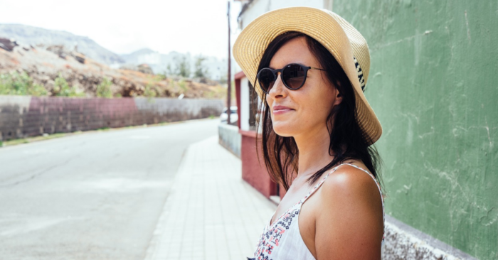 woman staining in front of house in spain - featured image